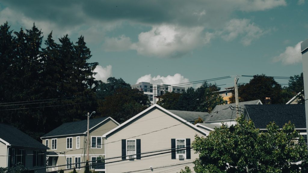 Detached suburban houses on a quiet residential street under a cloudy sky
