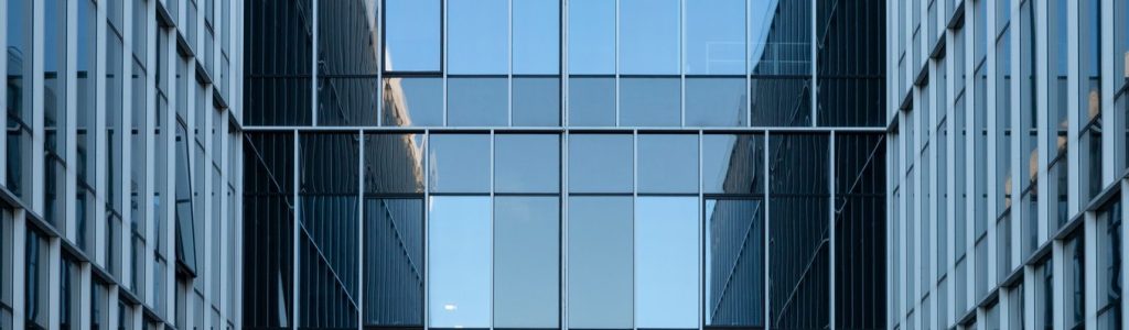 The reflective glass facade of a contemporary commercial building