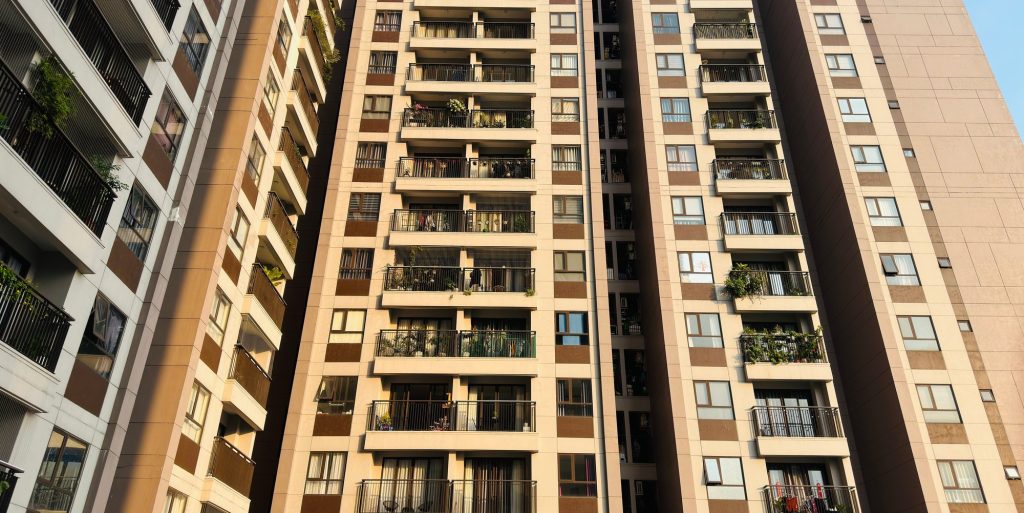 High-rise residential blocks with rows of balconies against a clear sky